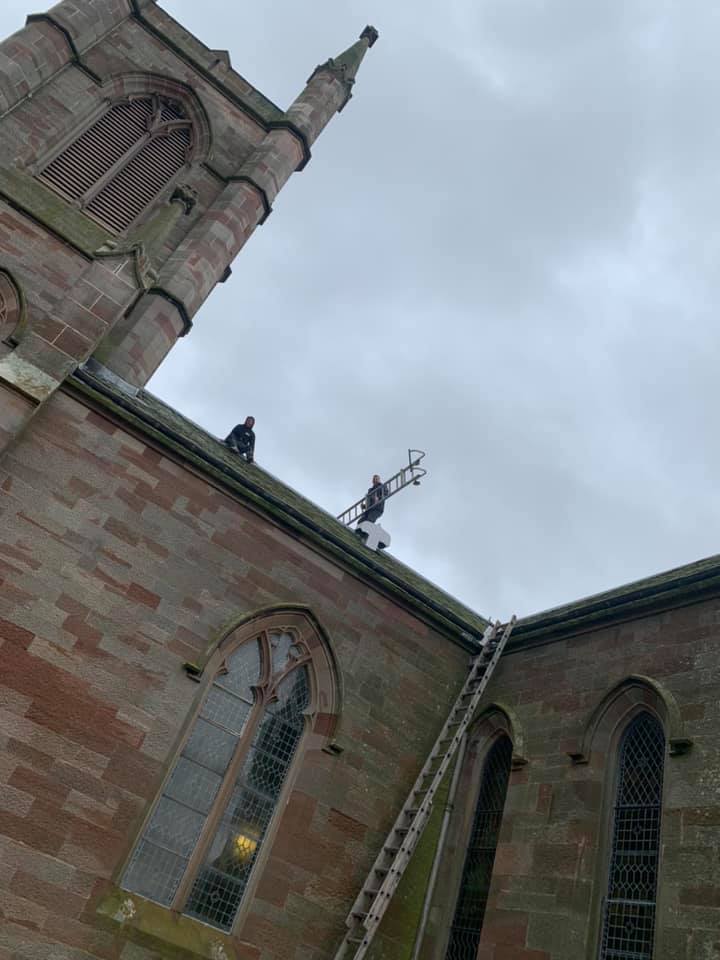 Roofers on top of a church